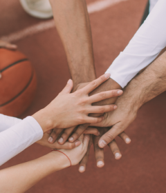 eSkillz Games - eSkillz Games - Making sports accessible to people everywhere - hands holding a plant - players showing togetherness before a Basketball game.